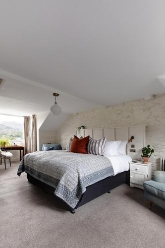 a bedroom with a large bed and a chair at Chestnut Villa in Grasmere