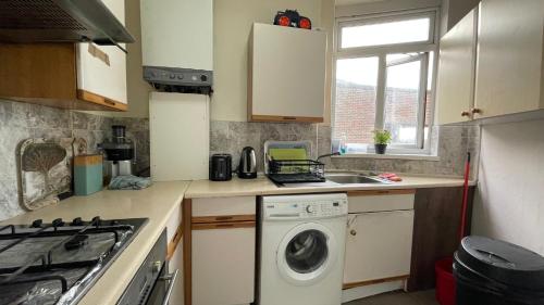 a kitchen with a washing machine and a sink at Single Room near Paddington in London