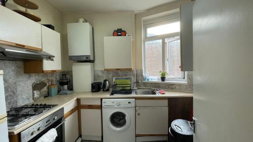 a kitchen with a washing machine and a sink at Single Room near Paddington in London