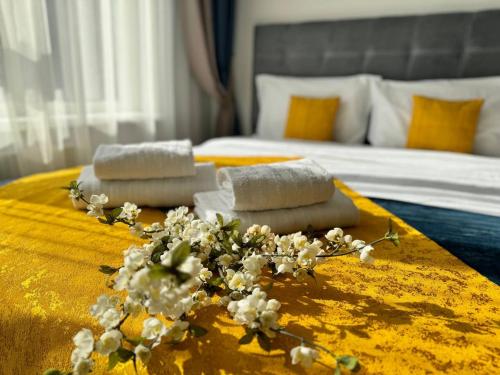 基輔的住宿－Люкс апартаменти в затишному ЖК бізнес класу，桌子上的两条毛巾,床上有鲜花