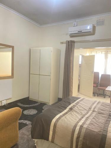 um quarto com uma cama, um armário e uma cadeira em Hilton inn em Ladysmith