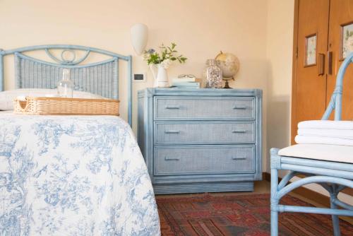 a bedroom with a blue dresser and a bed at Villa Arizona in Milano Marittima