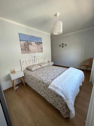 a bedroom with a bed and a table and a lamp at APARTAMENTO Casa Hortense in Olhão