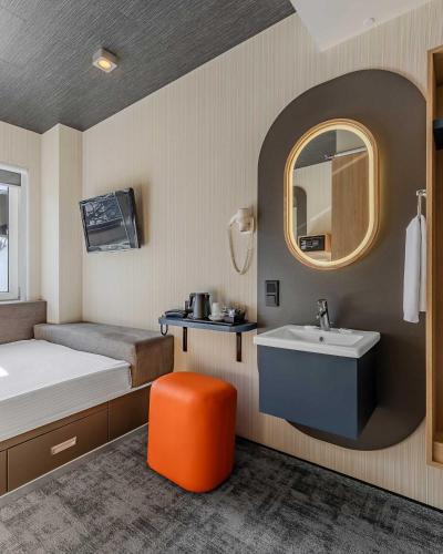 a room with a bed and a sink and a mirror at IQ Hotel in Kyiv