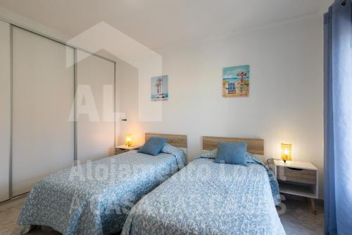 een slaapkamer met 2 bedden en een blauw dekbed bij Casa Sardine by ACasaDasCasas in Ericeira