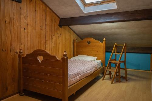 1 dormitorio con cama de madera y escalera en LE COTEAU Pavillon au calme 2 chambres 4-5 personnes, en Savigny-sur-Orge