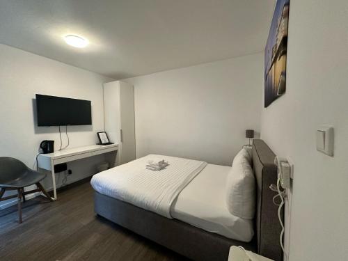 a small hotel room with a bed and a desk at dreams Düsseldorf in Düsseldorf