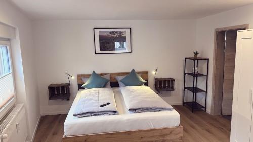 a bedroom with a large white bed with blue pillows at Heimatliebe Erfweiler Wohnung VIER in Erfweiler