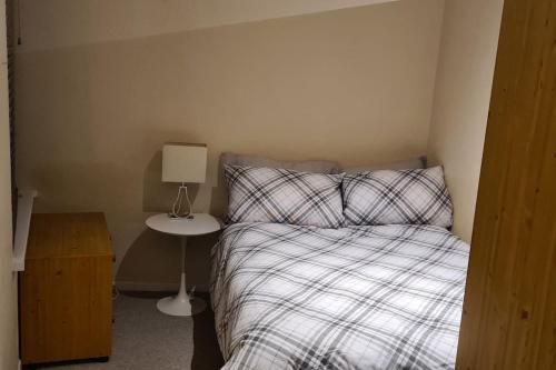 a small bedroom with a bed and a night stand at Radcliffe Studio in Nottingham