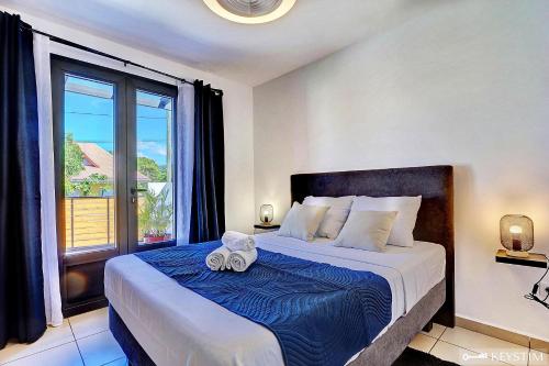 1 dormitorio con 1 cama con 2 toallas en La Maison Du Bonheur - Villa moderne avec SPA, en Saint-Joseph