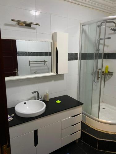 uma casa de banho com um lavatório e um chuveiro em Harmonie ville em Dakar