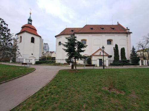 a large white building with a clock tower in a park at Flat near the Vyšehrad Castle in Prague