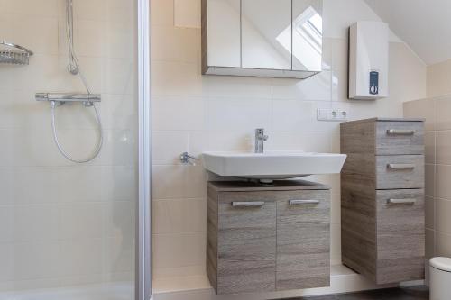 a bathroom with a sink and a shower at Haus Harle 50205 Ferienwohnung Harle 4 in Harlesiel