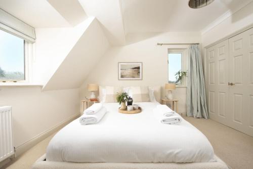 a white bedroom with a large white bed at The Nineteenth in Wadebridge