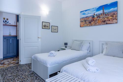 2 łóżka w pokoju z białymi ścianami w obiekcie HouSmart Galeotti 16 w Bolonii
