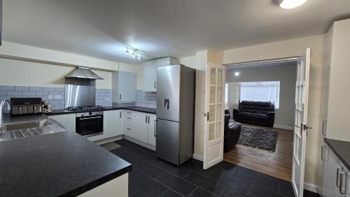 uma cozinha com um frigorífico e uma sala de estar em Entire Three Bedroom House in Birmingham em Birmingham