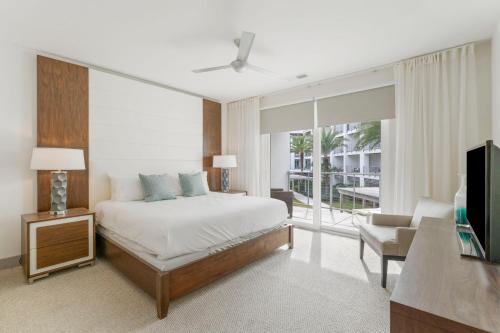 a bedroom with a bed and a living room at the Pointe Unit 326 in Rosemary Beach