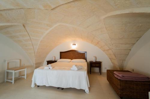 ein Schlafzimmer mit einem großen Bett in einer Steinmauer in der Unterkunft AFFITTACAMERE ANEMONE- SCIROCCO1 in Uggiano la Chiesa
