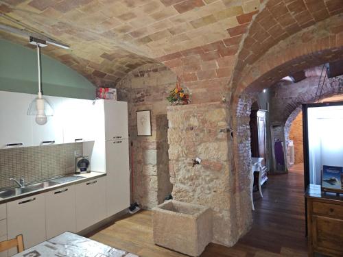 a kitchen with a sink and a stone wall at Bella Toscana in Pomarance