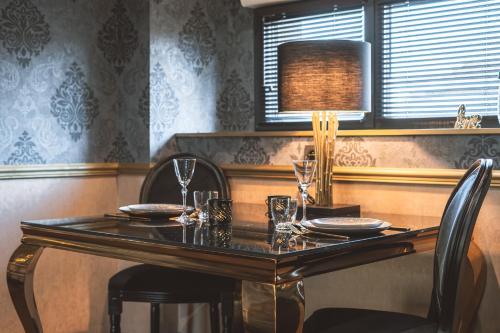 a dining room table with two chairs and a lamp at Love gite avec Spa nage privatif et espace coquin - Le Secret de l'Elixir in Argentré-du-Plessis