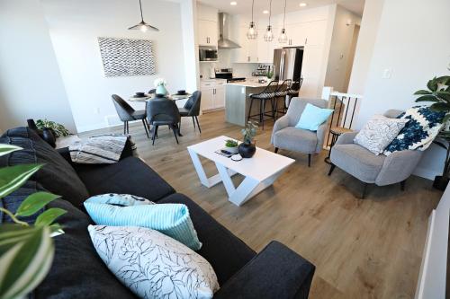 - un salon avec un canapé, des chaises et une table dans l'établissement Stylish Home with 3 King Beds,Garage,Disney+, à Edmonton