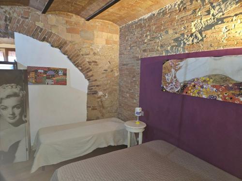 a room with two beds and a brick wall at Bella Toscana in Pomarance