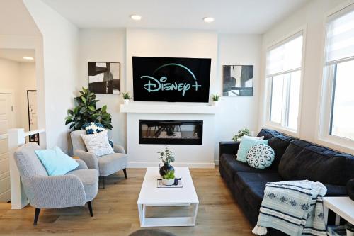a living room with a black couch and a fireplace at Stylish Home with AC, 3 King Beds, Garage, Disney in Edmonton