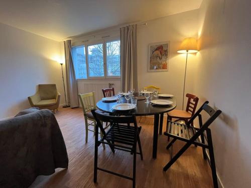 une salle à manger avec une table et des chaises et une chambre avec un canapé dans l'établissement Duplex élégance, à Arcueil