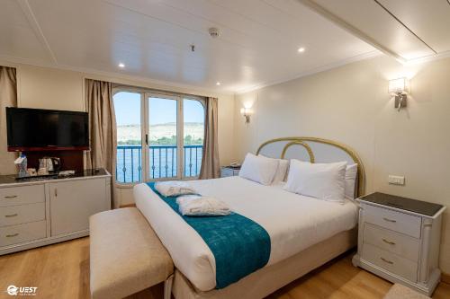 a bedroom with a large bed and a window at M/S Nile Quest Cruise - 4 or 7 Nights From Luxor each Monday and 3 or 7 Nights From Aswan each Friday in Luxor