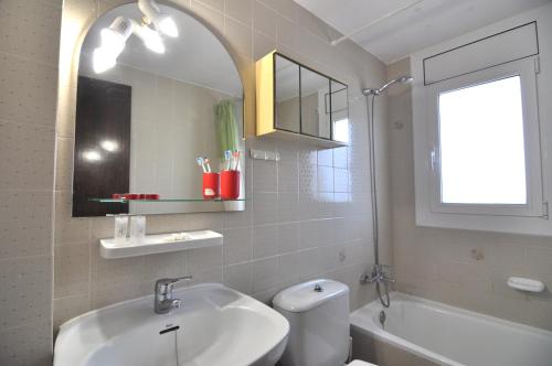 uma casa de banho com um lavatório, um WC e um espelho. em RNET - Playa Sol - Roses Costa Brava em Santa Margarita