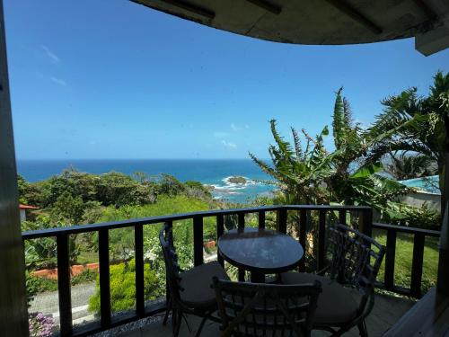a balcony with a table and chairs and the ocean at Ciel y Miel in Colón