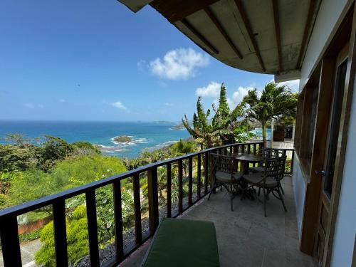 a balcony with a table and chairs and the ocean at Ciel y Miel in Colón