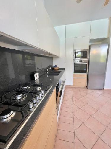 a kitchen with a stove top and a refrigerator at Fantastic Villa with pool for 7 guests on Albarella in Palazzo Vianello