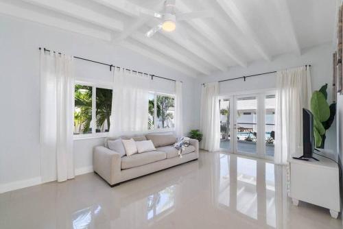 een witte woonkamer met een bank en een tv bij Together but with Privacy 3 Units and Private Pool in Fort Lauderdale