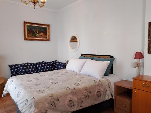 a bedroom with a bed and a painting on the wall at LIGEIA HOME in Nafplio