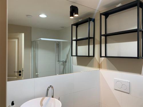 a bathroom with a shower and a sink and a mirror at Hotel Desatero in Mikulov
