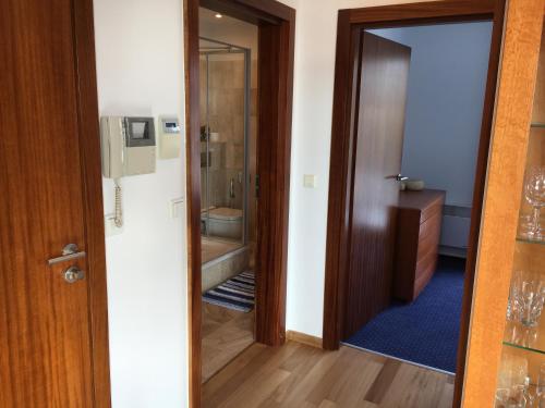a bathroom with a shower and a toilet and a door at Apartament Aloza 7 na wydmie w Juracie in Jurata