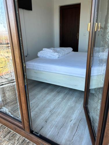 eine Glastür, die zu einem Schlafzimmer mit einem Bett führt in der Unterkunft Gura Raului Casa de Vacanta in Gura Râului