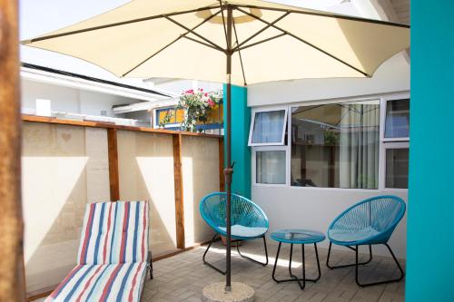 a patio with two chairs and an umbrella at Pianoforte holiday apartments in Swakopmund