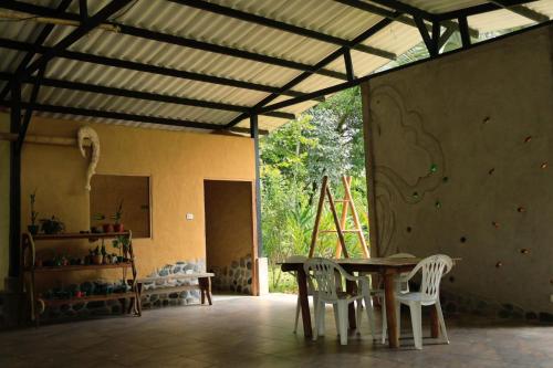 a room with a table and chairs and a wall at Finca Turistica Moniyamena, Encuentro con la Naturaleza in Villavicencio