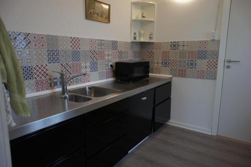 a kitchen with a sink and a microwave at (id. 099) Grønnevej 35 in Esbjerg