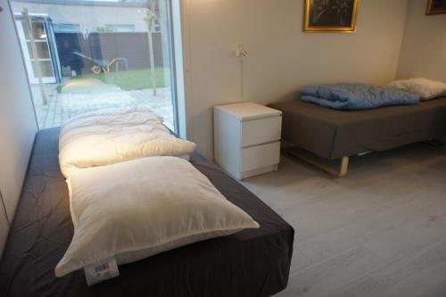 a bedroom with two beds and a window at (id. 099) Grønnevej 35 in Esbjerg