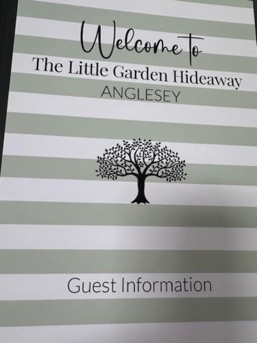a book with a tree on a striped page at The Little Garden Hideaway with Stunning Sea Views and Garden in Holyhead