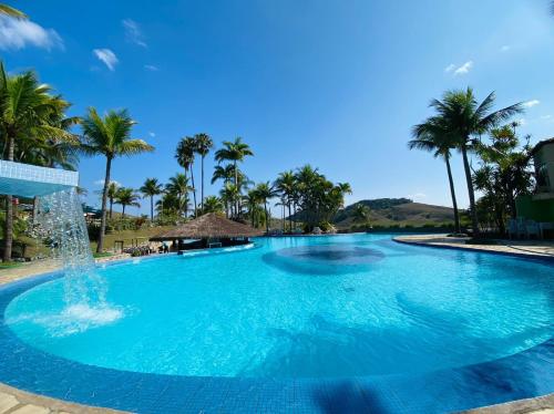 a large pool with palm trees and a fountain at Flat Particular Adeias das Aguas Park Resort in Barra do Piraí