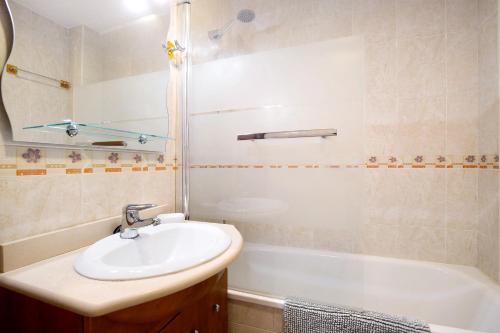 a bathroom with a sink and a shower and a tub at La caleta in La Cala de Mijas
