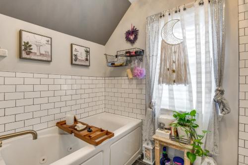 a bathroom with a white tub and a window at Chic Baltimore Retreat - 6 Mi to Downtown! in Baltimore