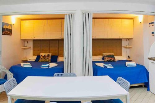 2 Betten in einem Zimmer mit Tisch und Stühlen in der Unterkunft Apparthenope in Neapel
