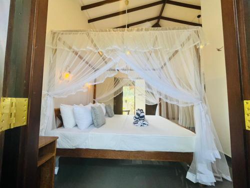 a bedroom with a canopy bed with white curtains at Princess Rose Luxury Apartments in Talpe