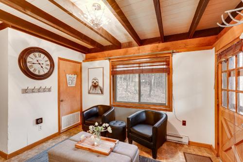 a living room with two chairs and a table and a clock at Private Hot Tub Cabin 1 Mi to Beech Mountain! in Beech Mountain
