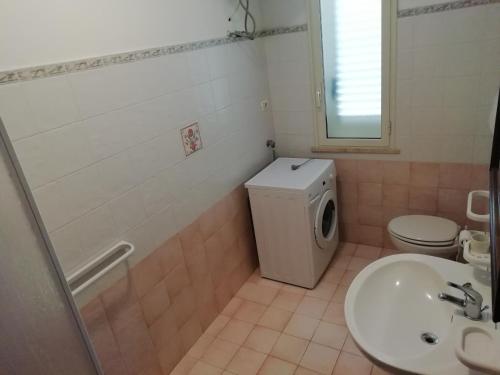 bagno con servizi igienici, lavandino e lavatrice di Casa vacanze otranto a Otranto